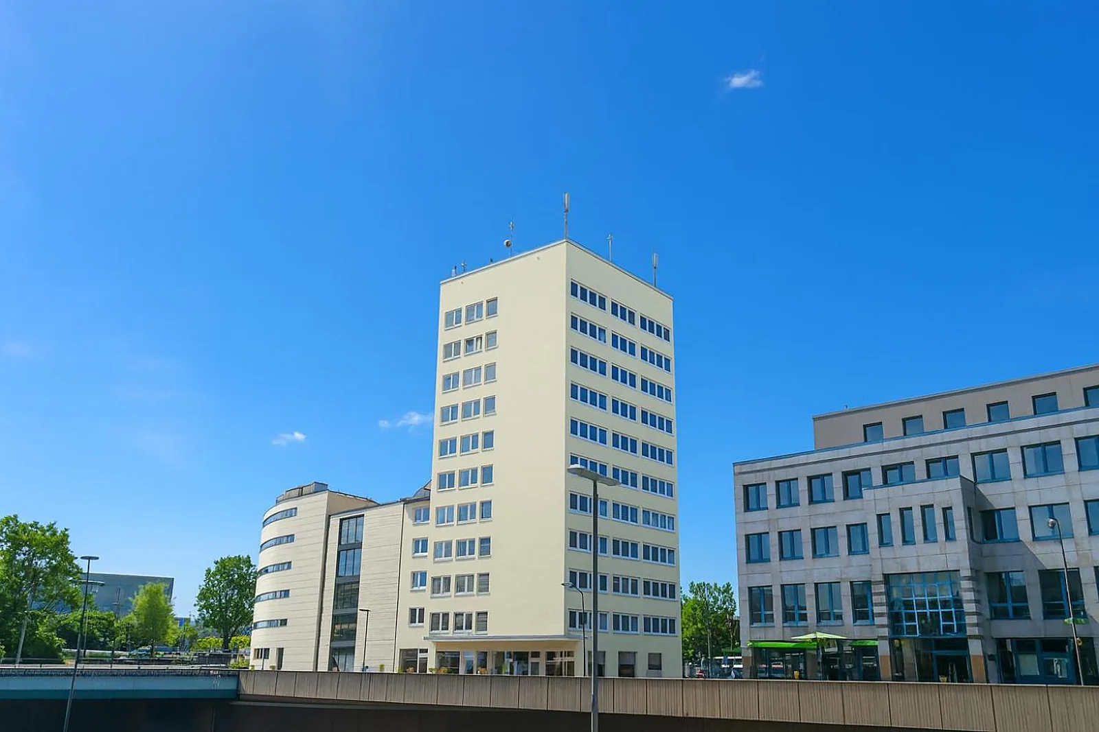 Das helle Wohnhochhaus am Rheinlanddamm 6 in Dortmund unter blauem Himmel