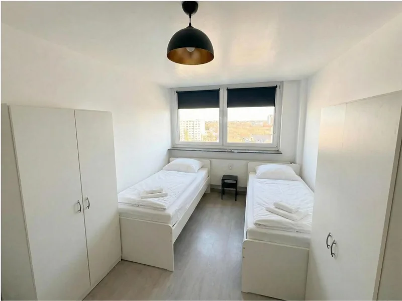 Zweibettzimmer mit zwei Kleiderschränken und Pendelleuchte am Rheinlanddamm 6