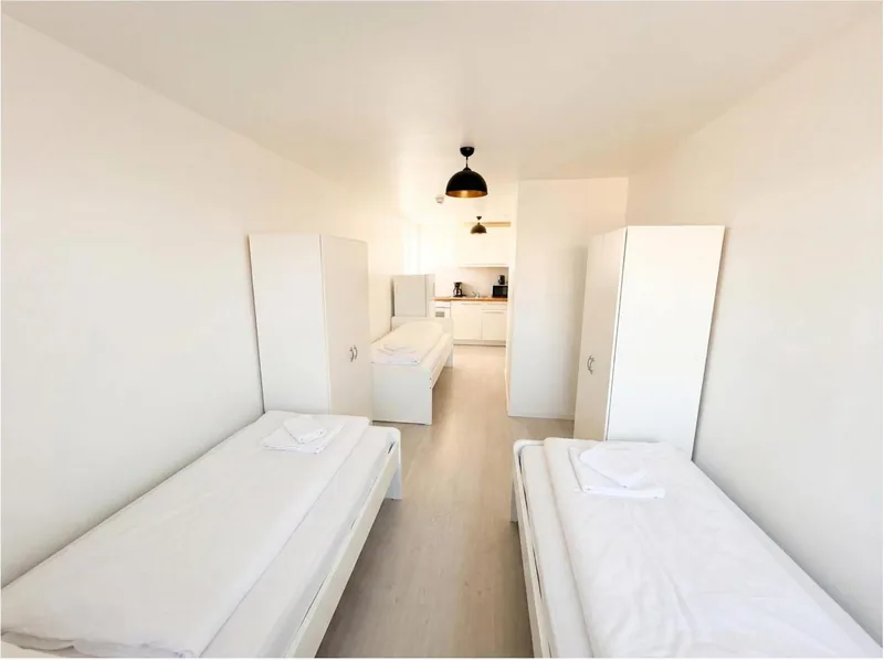 Langes Zimmer mit zwei Einzelbetten und Schränken am Rheinlanddamm 6