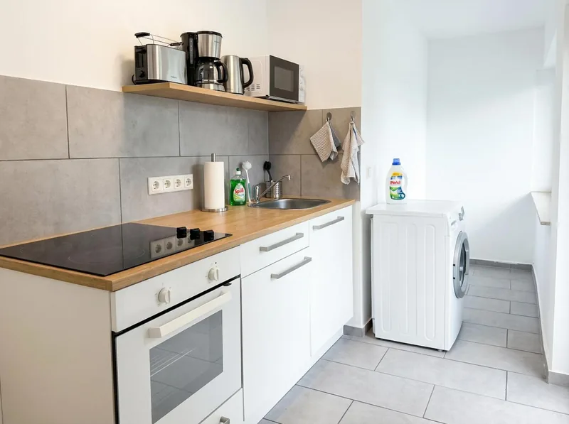 Küche mit Backofen, Kochfeld und Waschmaschine am Rheinlanddamm 6
