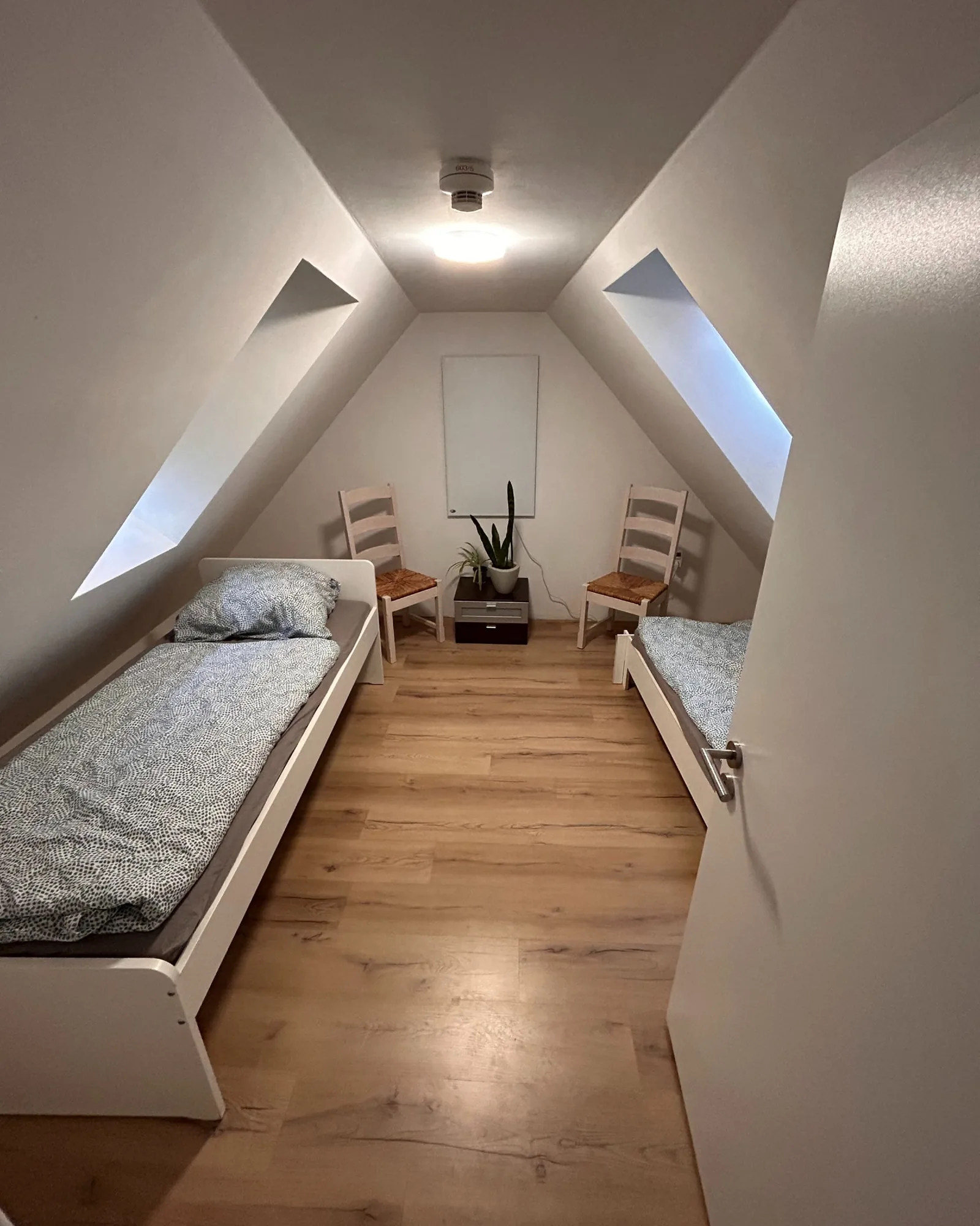 Zimmer unter der Dachschräge mit zwei Betten im Haus am Evinger Platz