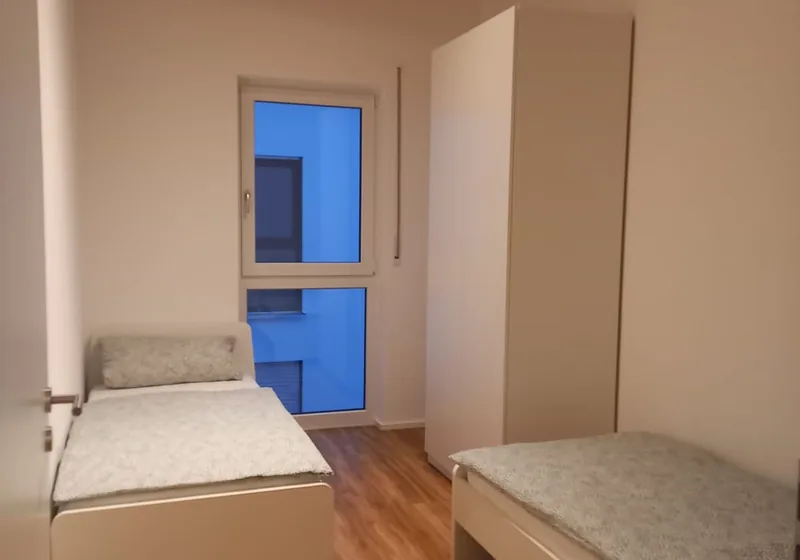 Zweibettzimmer mit großem Fenster im Haus an der Persebecker Straße